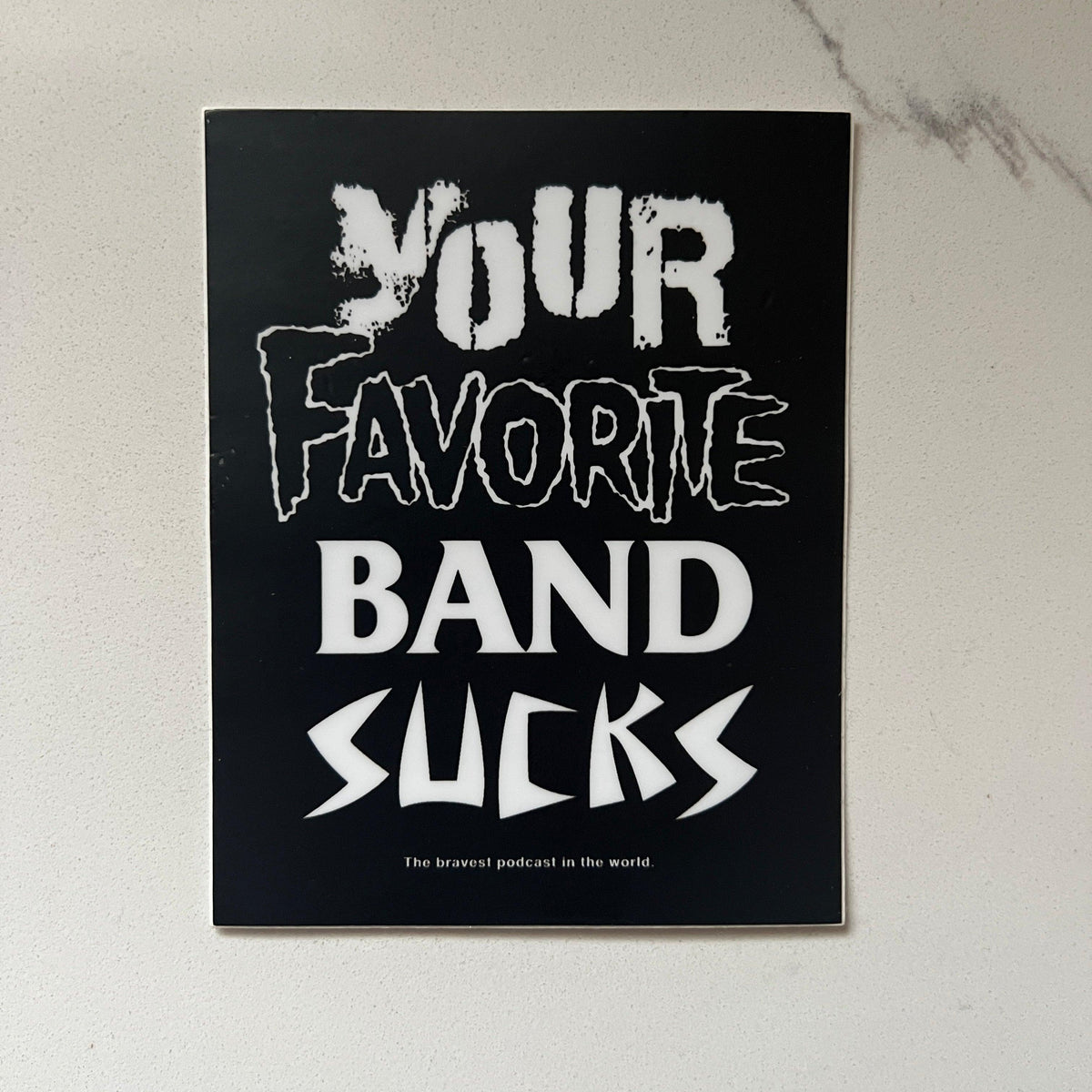 Your Favorite Metal Band Sucks sticker, black vinyl sticker with white heavy-metal style lettering