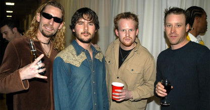Your Favorite Band Sucks gift card joke photo: four guys posing with drinks at a party