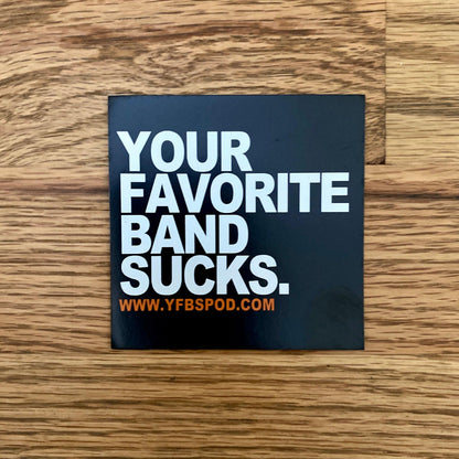 Your Favorite Band Sucks Magnet, black 3x3 inch square magnet with white lettering on a wood surface