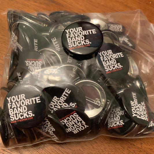 Your Favorite Band Sucks Pin, a pile of 1.5 inch black button pins with white YFBS logo lettering